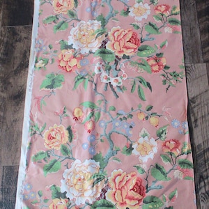 May include: Pink fabric with a floral print featuring large pink, yellow, and white roses with green leaves and small blue flowers. The fabric has the text "Boncland Fabrics, Chicago, Ill." printed on the side.