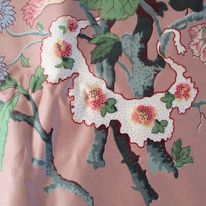 May include: A pink fabric with a floral pattern featuring white, pink, and green flowers and leaves. The fabric has a vintage feel and would be perfect for a variety of crafting projects.