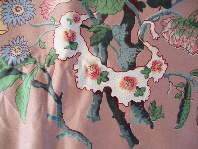 May include: A pink fabric with a floral pattern featuring white, pink, and green flowers and leaves. The fabric has a vintage feel and would be perfect for a variety of crafting projects.