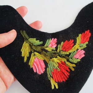May include: A black velvet collar with a floral embroidery design. The flowers are pink, red, and yellow.