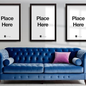 May include: Three black picture frames with white mats and the text "Place Here" in each frame. The frames are hanging on a white wall above a blue velvet sofa with a pink pillow.