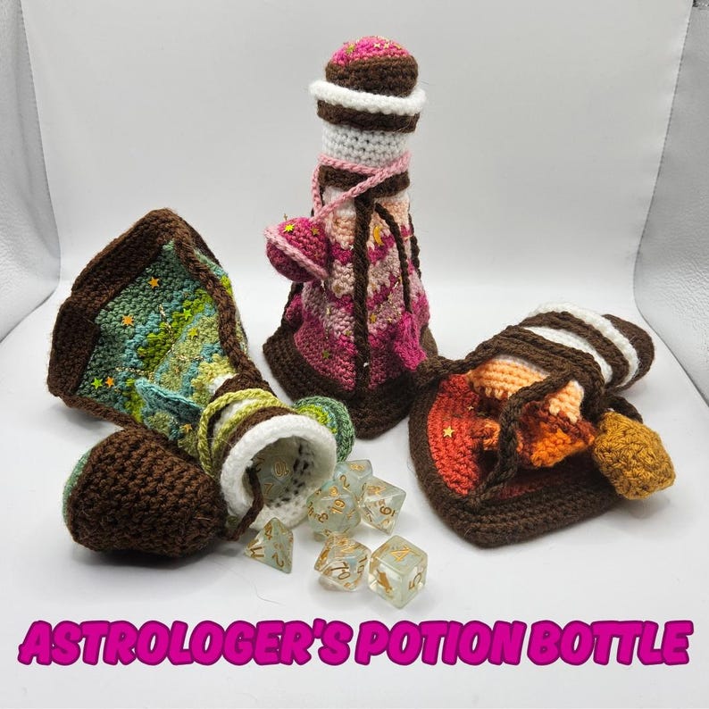 Text reads: Astrologer's Potion Bottle.
On the left is a green crocheted potion bottle which lies on its side with a set of polyhedral gaming dice spilling out of it, often used in DnD or CnC or other tabletop games. In the middle is a pink striped crocheted potion bottle standing tall. And on the right is an orange crocheted potion bottle with has been squashed or flattened to show its softness.