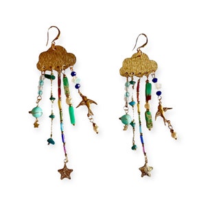 May include: Gold cloud-shaped earrings with colourful beads, stars, and birds dangling from them.
