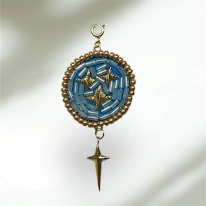 May include: A gold pendant featuring a blue and gold beaded circle with a star design. The pendant hangs from a gold chain and has a gold star charm.