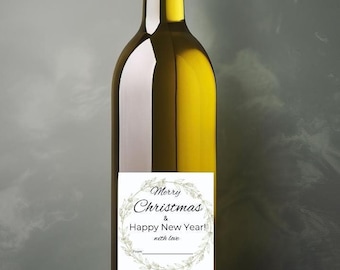 May include: A clear glass bottle of white wine with a gold screw top. The bottle has a white label with a green wreath design and the text "Merry Christmas & Happy New Year! with love".