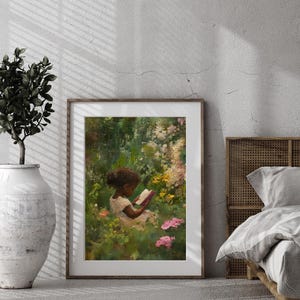May include: A framed painting of a young girl sitting in a garden, reading a book. The girl is wearing a white dress and has dark brown hair. The garden is lush and green, with pink flowers in the foreground.