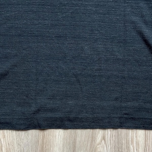 May include: A dark gray t-shirt with a textured, slightly rough surface.
