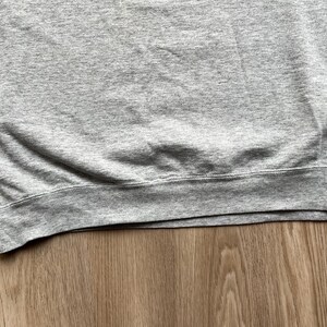 May include: A grey sweatshirt with a ribbed hem.