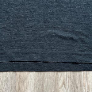 May include: A dark gray t-shirt with a ribbed texture and a hemmed bottom edge.
