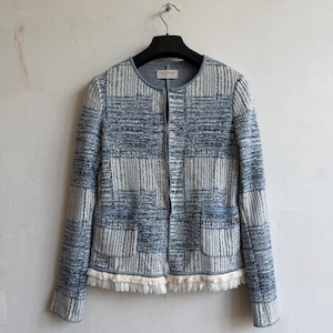 May include: A long-sleeved jacket featuring a blue and white textured grid pattern. The garment has a round neckline, a front zipper closure, two front pockets, and a white fringe trim along the bottom hem. The interior label reads FALCONERI.