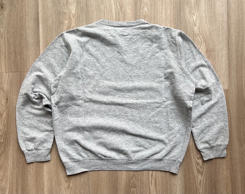 May include: A grey long-sleeved sweatshirt with a crew neck.