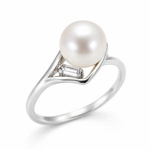 May include: A silver-toned ring featuring a single round white pearl set above a small, clear, rectangular baguette-cut gemstone. The metal band has a smooth, polished finish and a split-shank design that cradles the pearl and the accent stone.