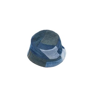 May include: A blue denim bucket hat with a patchwork design. The hat is made of different shades of blue denim and has a wide brim.