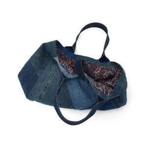 May include: A blue denim tote bag with a paisley patterned lining. The bag is made from recycled denim and has a patchwork design.