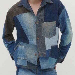 Puede incluir: Una chaqueta vaquera azul con un dise&ntilde;o de patchwork. La chaqueta tiene cuello, mangas largas y cierre de botones. La chaqueta est&aacute; hecha de diferentes tonos de mezclilla azul y tiene un bolsillo en el pecho izquierdo.