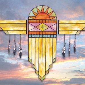 May include: A stained glass window design featuring a stylized sun with a yellow, orange, and red color scheme. The sun is surrounded by two wings with a geometric pattern in shades of yellow and brown. The wings are adorned with white feathers hanging from the bottom.