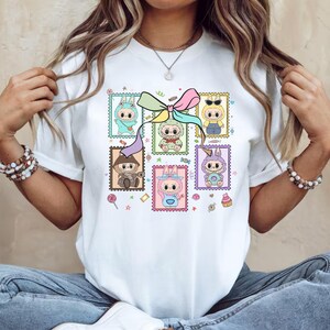 Camiseta Labubu estilo sello: Camisa Labubu con marco de franqueo y lazo pastel: un bonito diseño coleccionable.