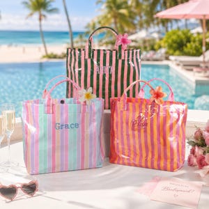 Peut inclure: Trois sacs fourre-tout rectangulaires à rayures verticales et poignées supérieures. Le sac arrière est vert et rose avec le nom Anita. Le sac avant gauche est rayé pastel avec le nom Grace. Le sac avant droit est orange et rose avec le nom Elisa.