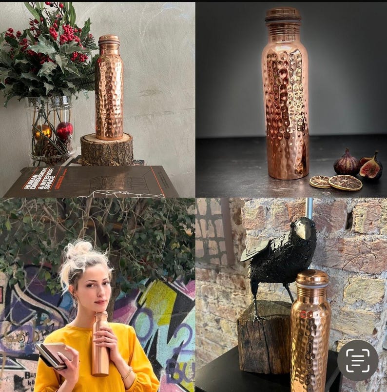 May include: A cylindrical copper water bottle featuring a hammered, textured surface and a matching metallic screw-top lid. The bottle has a narrow neck and a wide body, reflecting light across its polished, reddish-brown metallic finish.