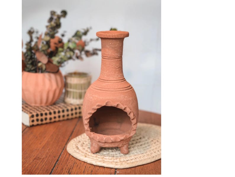 Pu&ograve; includere: Un bruciatore di incenso in terracotta con un'apertura rotonda e tre gambe. Il bruciatore &egrave; decorato con un motivo testurizzato.