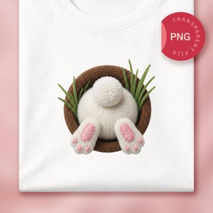 May include: White sweatshirt featuring a knitted bunny bottom with pink paw pads and a fluffy tail, emerging from a brown woven basket with green grass. The image includes a red circle with the text "TRANSPARENT FILE PNG".