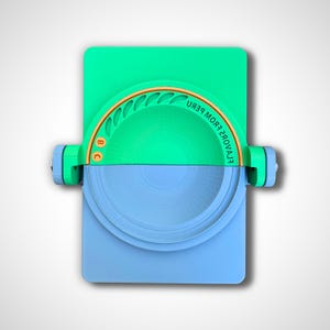 May include: A green and blue plastic device with a gold rim and the text "EL AYAVOREZ FROM PERU" on the rim. The device has two parts that can be rotated.