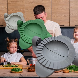 May include: Three different colored plastic tools for making dumplings. The tools are shaped like a circle with a series of ridges around the edge. The tools are open and ready to be used to make dumplings.