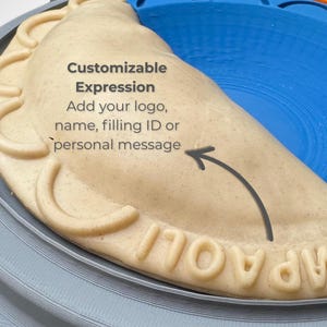 May include: A beige, semi-circular dough press mould featuring a crimped edge and the embossed text "CAMPOLI". The surface includes the printed text "Customizable Expression Add your logo, name, filling ID or personal message" with an arrow.