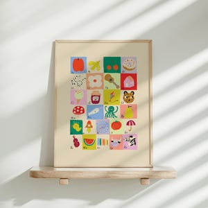 May include: A framed alphabet art print featuring colorful illustrations of various objects, each representing a letter. The artwork includes images of an apple, butterfly, donut, ice cream, and more. The print is displayed on a wooden shelf against a white wall.