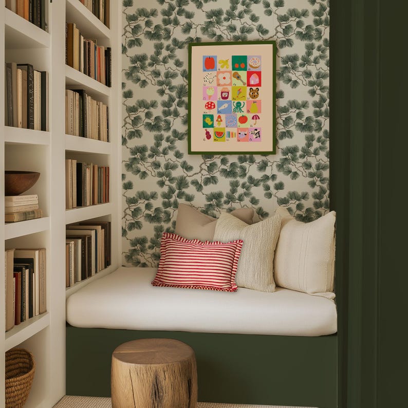 May include: A cozy reading nook with a white bench, pillows, and a framed art print. The print features colorful illustrations. The room has a green accent wall and a wooden stump side table. Bookshelves are on the left.