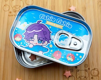 May include: A rectangular metal tin with a pull-tab lid featuring a blue background, a cartoon character with purple hair holding a fish, and the text "fishie fishie fresh & tasty". The label includes the text "NET WT. 3.06 OZ (86.75g)".