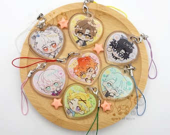 May include: A collection of six heart-shaped acrylic charms featuring anime-style character illustrations. Each charm includes a metal lobster clasp and a colorful nylon cord. One charm displays the text 707 in yellow, while others show various expressions.