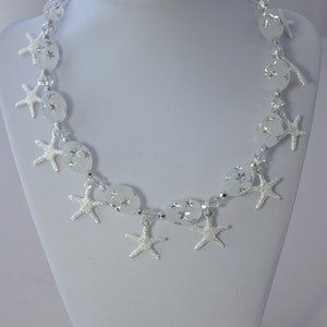 Starfish necklace made with silver plated starfish charms between white oval starfish cut beads with clear swarovski crystals.