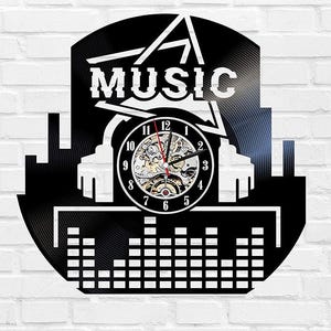 Puede incluir: Reloj de pared negro con la palabra "MUSIC" en blanco, con una silueta de paisaje urbano y una esfera de reloj con engranajes visibles. El diseño del reloj incorpora una estética de disco de vinilo.