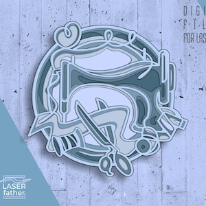 May include: A layered paper design featuring a sewing machine, scissors, and thread spool in shades of blue and gray. The design is circular and includes the text "DIGITAL FILES FOR LASER CUT" and file type abbreviations.