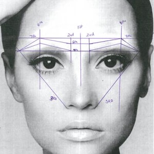 Pode incluir: Imagem a preto e branco de um rosto com linhas azuis que indicam as proporções faciais. As linhas são numeradas e usadas para maquiagem ou análise facial. A pessoa tem cabelo escuro e está olhando para a frente.