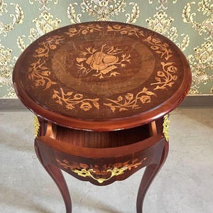 Mesa lateral artesanal em estilo barroco, acabamento em madeira brilhante, detalhes em latão