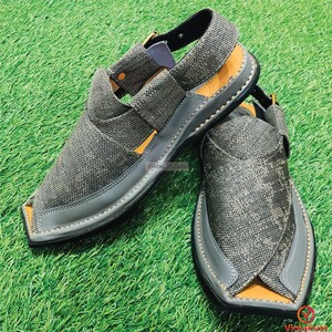 May include: A pair of gray canvas sandals with a pointed toe and a strap across the top of the foot. The sandals have a black leather sole and a brown leather insole.
