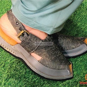 May include: A pair of gray and brown sandals with a buckle strap. The sandals have a pointed toe and a thick sole.