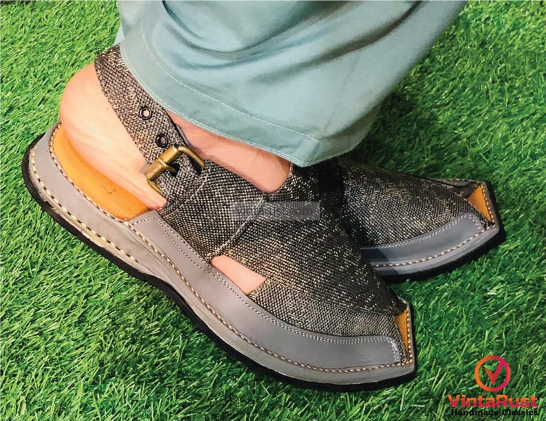 May include: A pair of gray and brown sandals with a buckle strap. The sandals have a pointed toe and a thick sole.