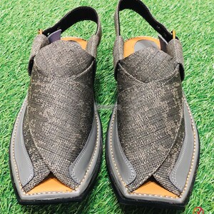 May include: A pair of gray leather sandals with a criss-cross strap design. The sandals have a pointed toe and a closed back.