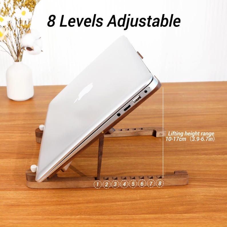 May include: A wooden laptop stand supporting a silver laptop. The stand offers 8 adjustable levels, with a lifting height range of 10-17cm. The image includes the text "8 Levels Adjustable".