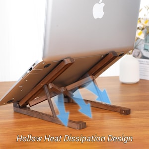 May include: A wooden laptop stand with a hollow heat dissipation design. The stand is angled to elevate the laptop, with blue arrows indicating airflow. The laptop is silver with the Apple logo.