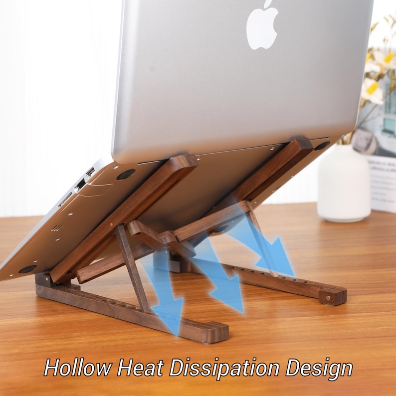 May include: A wooden laptop stand with a hollow heat dissipation design. The stand is angled to elevate the laptop, with blue arrows indicating airflow. The laptop is silver with the Apple logo.
