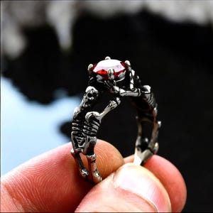 Anillo de calavera oscura de acero inoxidable / Anillo de compromiso gótico con piedra preciosa roja / Anillo de mano de esqueleto del amor a la muerte / Joyería gótica única.