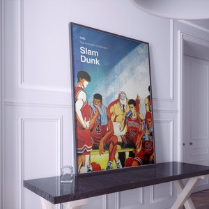 Puede incluir: Un póster vintage para la serie de anime "Slam Dunk" con un grupo de jugadores de baloncesto con uniformes rojos y blancos. El póster tiene el título "Slam Dunk" y el año "1993" impreso en él.