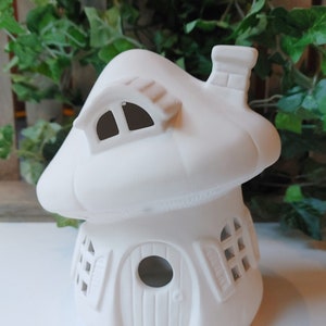 May include: White ceramic mushroom house with a chimney, a door, and two windows. The house is unpainted and ready to be decorated.