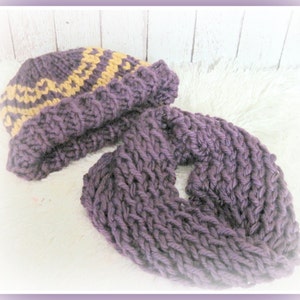 May include: A purple knitted hat with a yellow and brown geometric pattern and a matching purple infinity scarf.