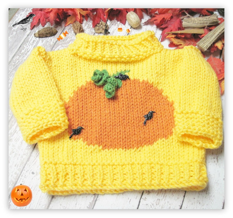 K&ouml;nnte beinhalten: Ein gelber Strickpullover mit einem K&uuml;rbisdesign auf der Vorderseite. Der K&uuml;rbis ist orange und hat einen gr&uuml;nen Stiel und schwarze Perlenakzente.