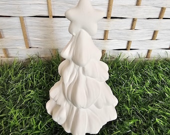 May include: White ceramic Christmas tree ornament with a star on top. The ornament has a loop for hanging.